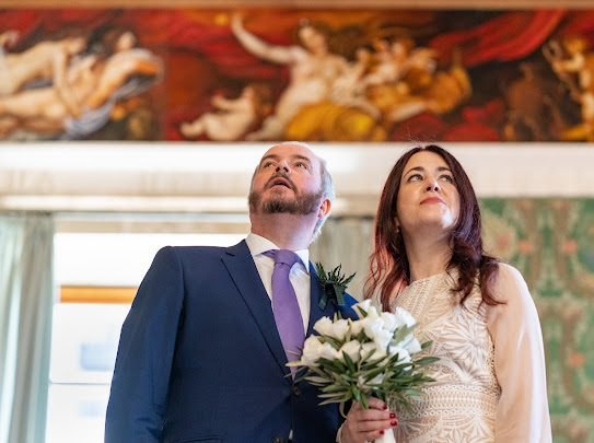 Bride and groom gazing up in wonder beneath a painted fresco ceiling at their civil wedding in a Sicilian palazzo