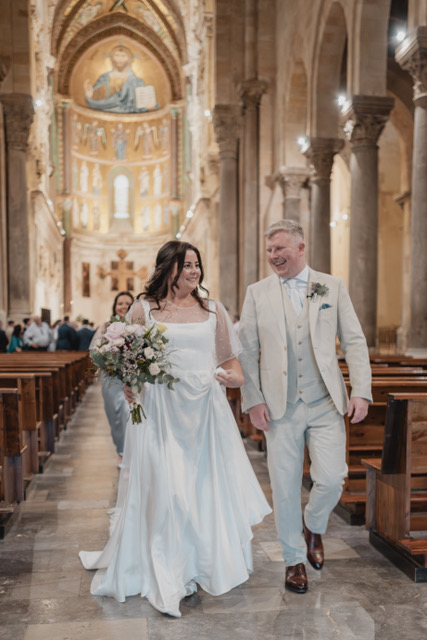 Gráinne and Phil walking the aisle under the golden mosaics of the Duomo di Cefalù, Sicily