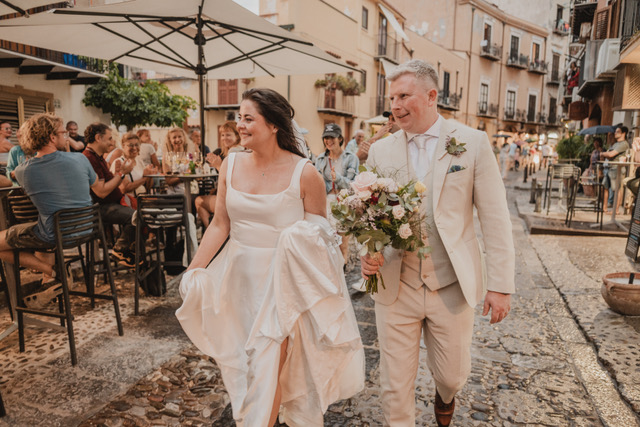 Gráinne and Phil on a cobbled Cefalù street as café guests applaud