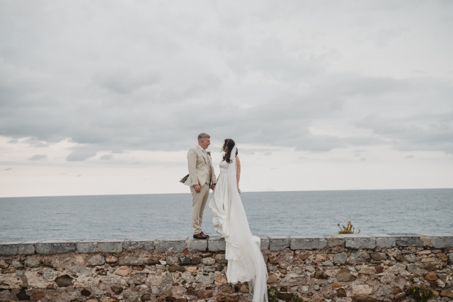 Gráinne and Phil facing each other on a sea wall