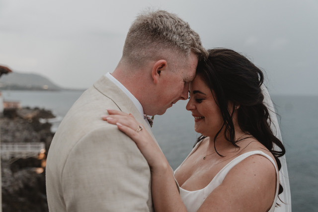Close portrait of Gráinne and Phil, foreheads touching by the sea