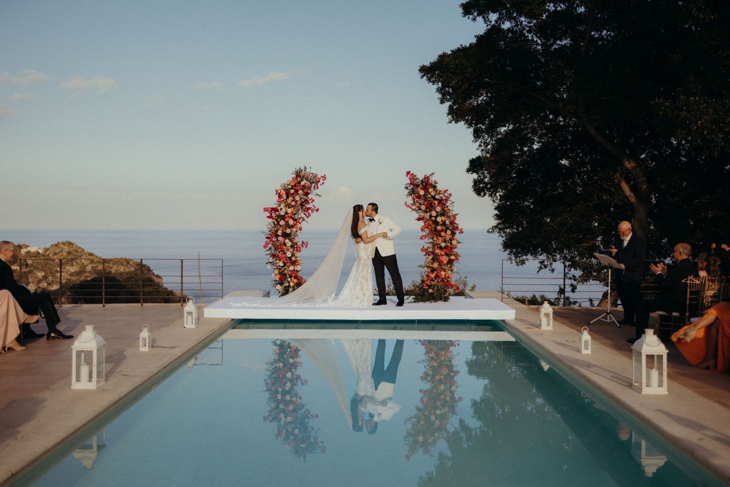 Stunning poolside ceremony with floral arch