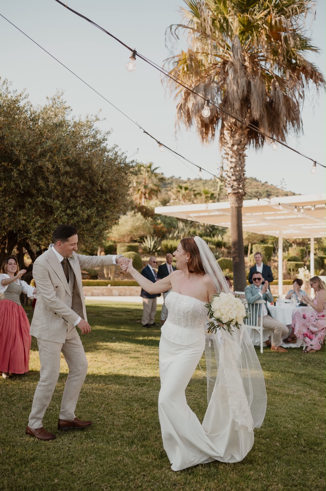 Jessica and Seb sharing their first dance beneath festoon string lights