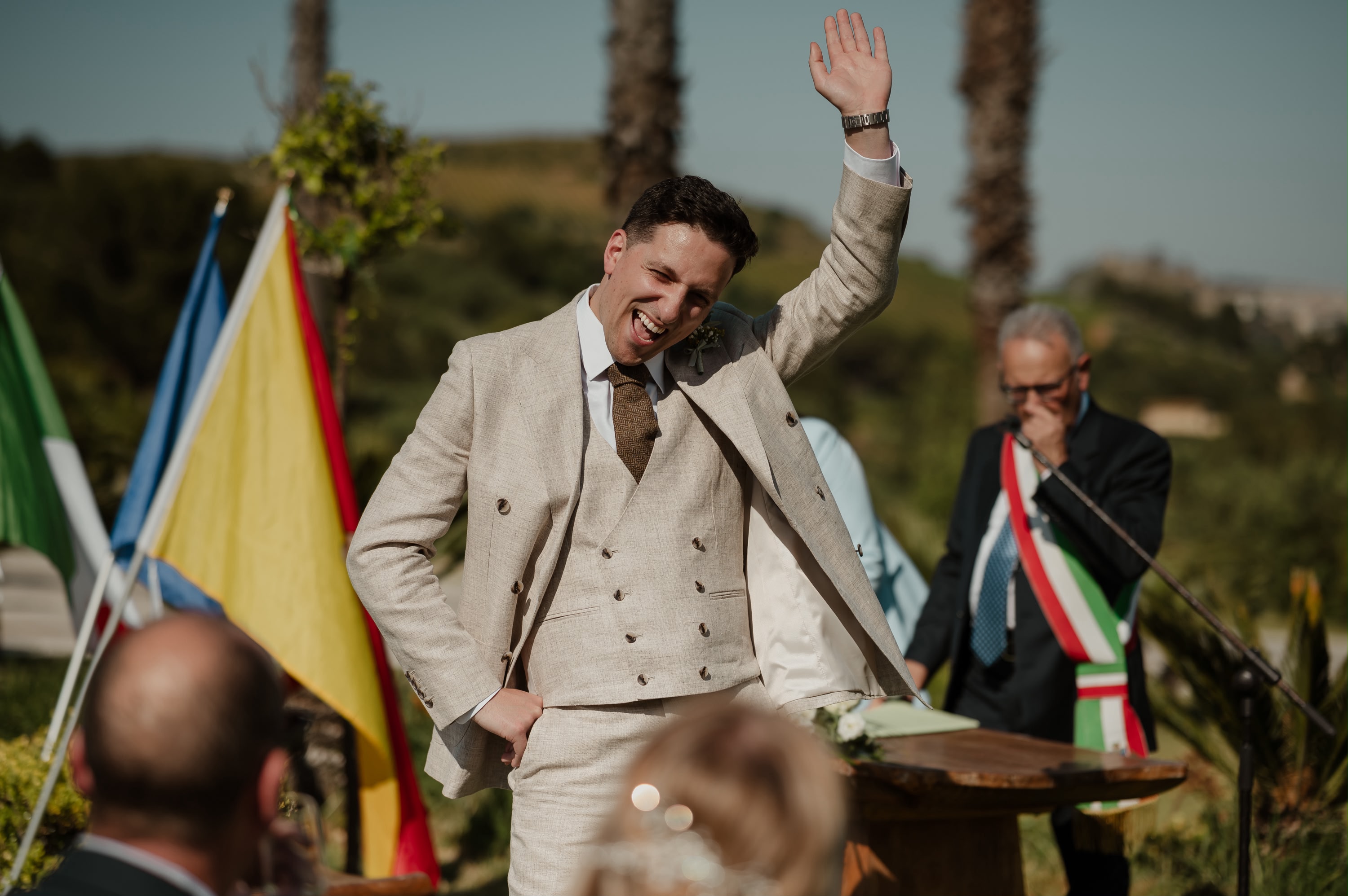 Seb laughing during the civil ceremony beside the Italian officiant wearing the tricolour sash