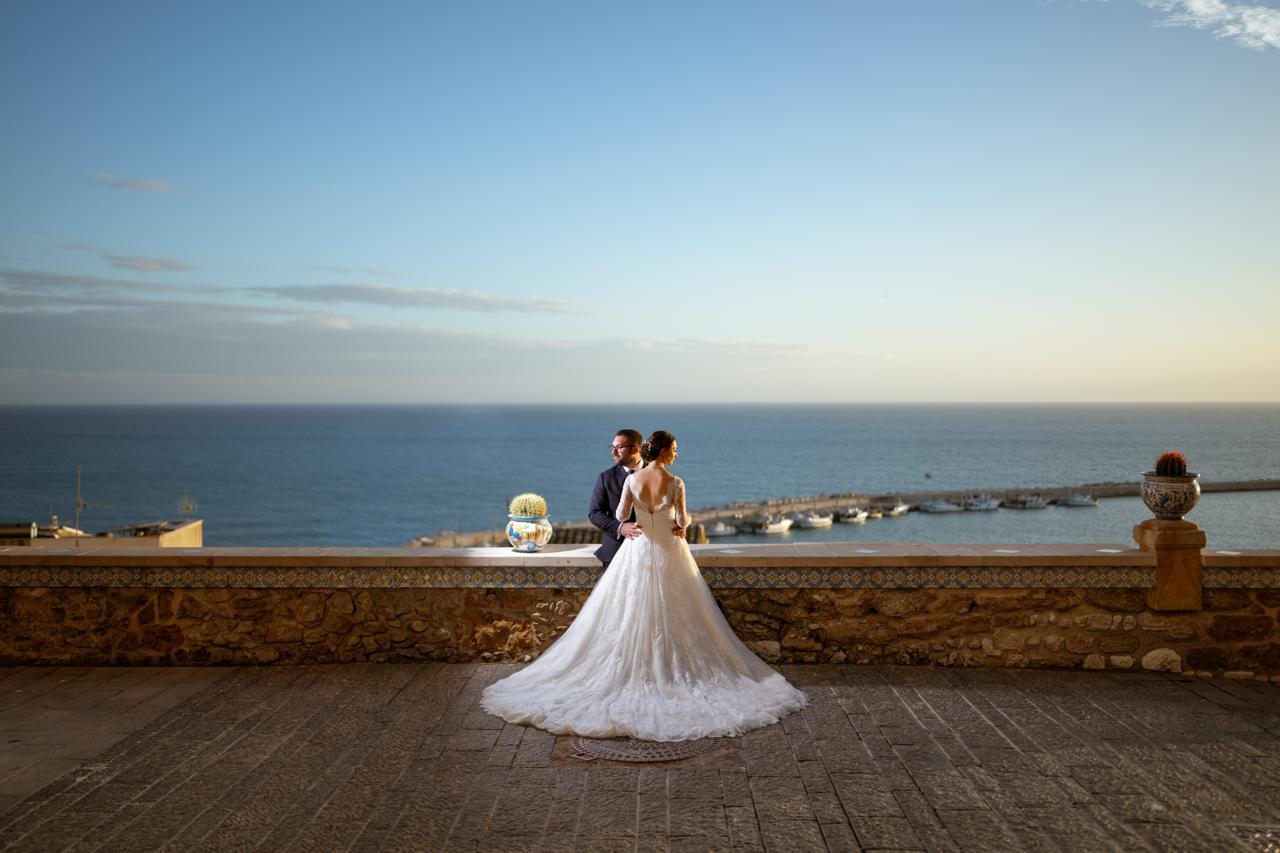 Newlyweds on a terrace overlooking the sea and harbour in Sciacca