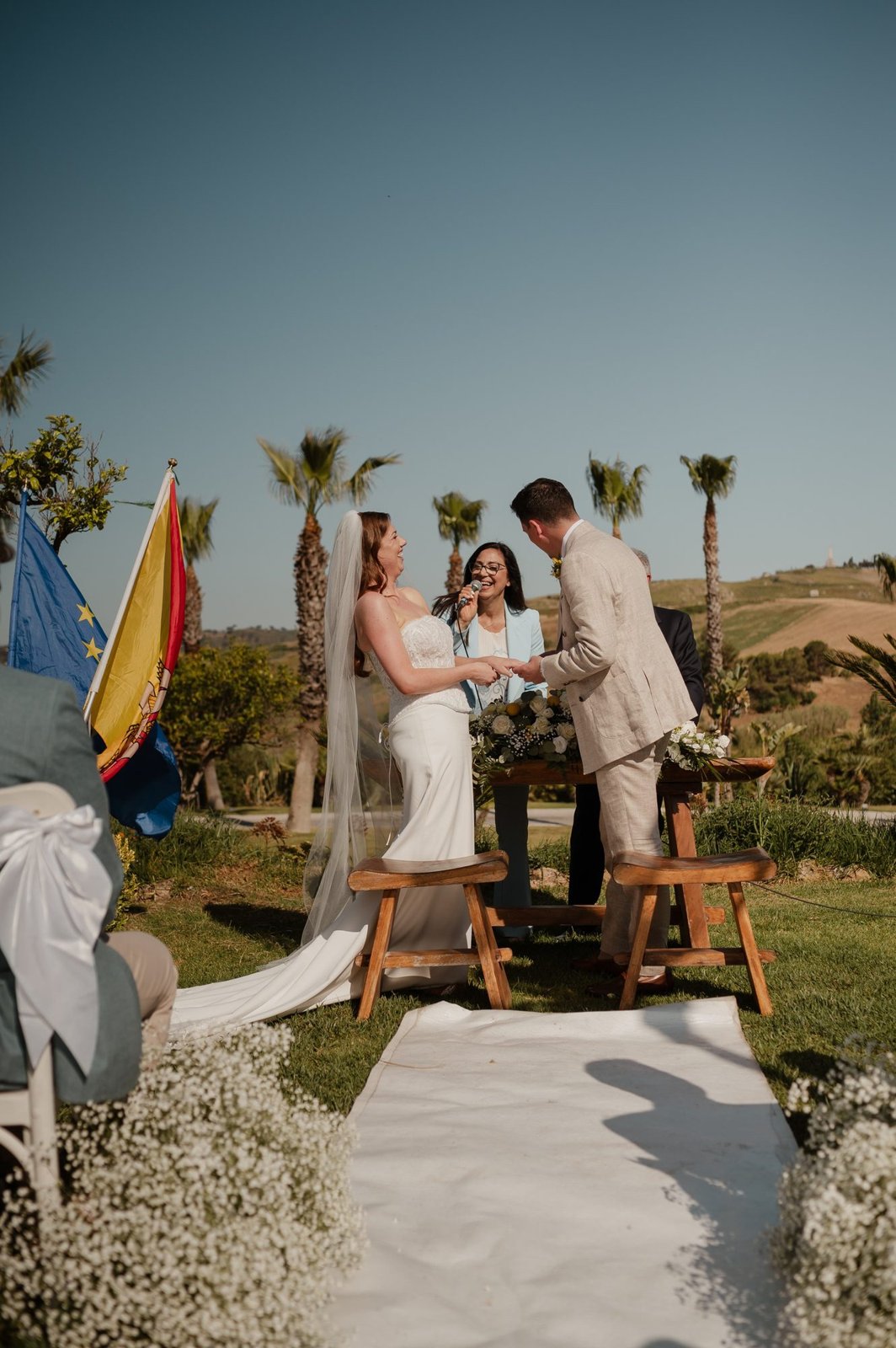 La wedding planner Sabina con il microfono mentre Jessica e Seb si scambiano le promesse all’aperto in Sicilia