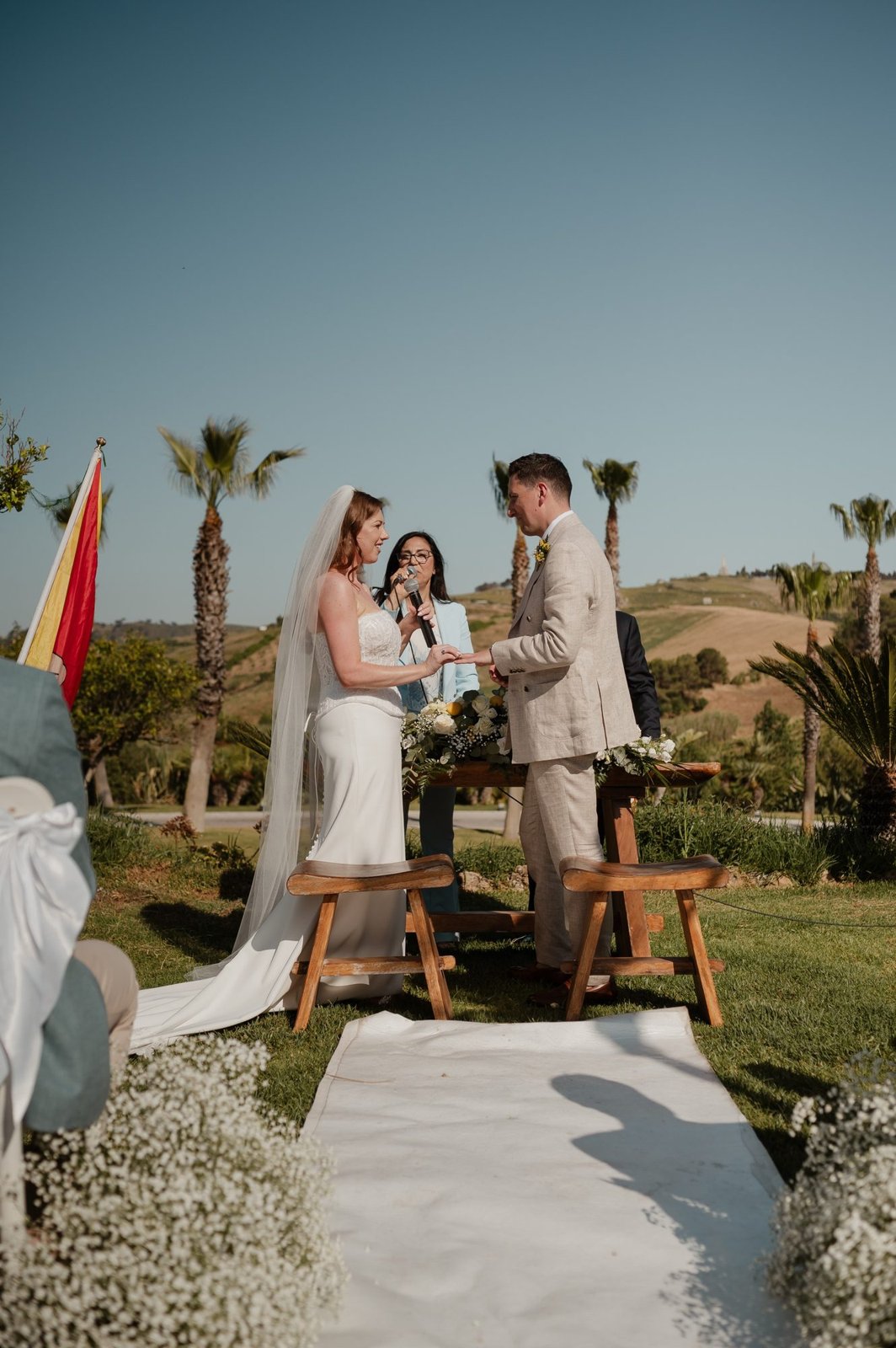 Sabina assiste allo scambio degli anelli nella soleggiata cerimonia in giardino di Jessica e Seb in Sicilia