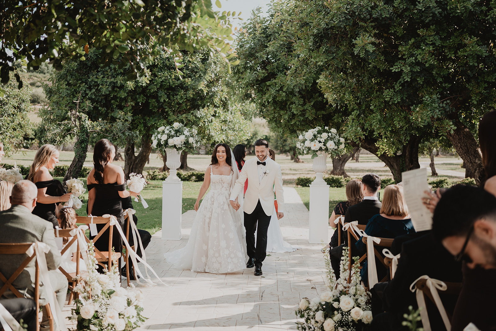 Lidia and Rian walking back down the aisle hand in hand as newlyweds