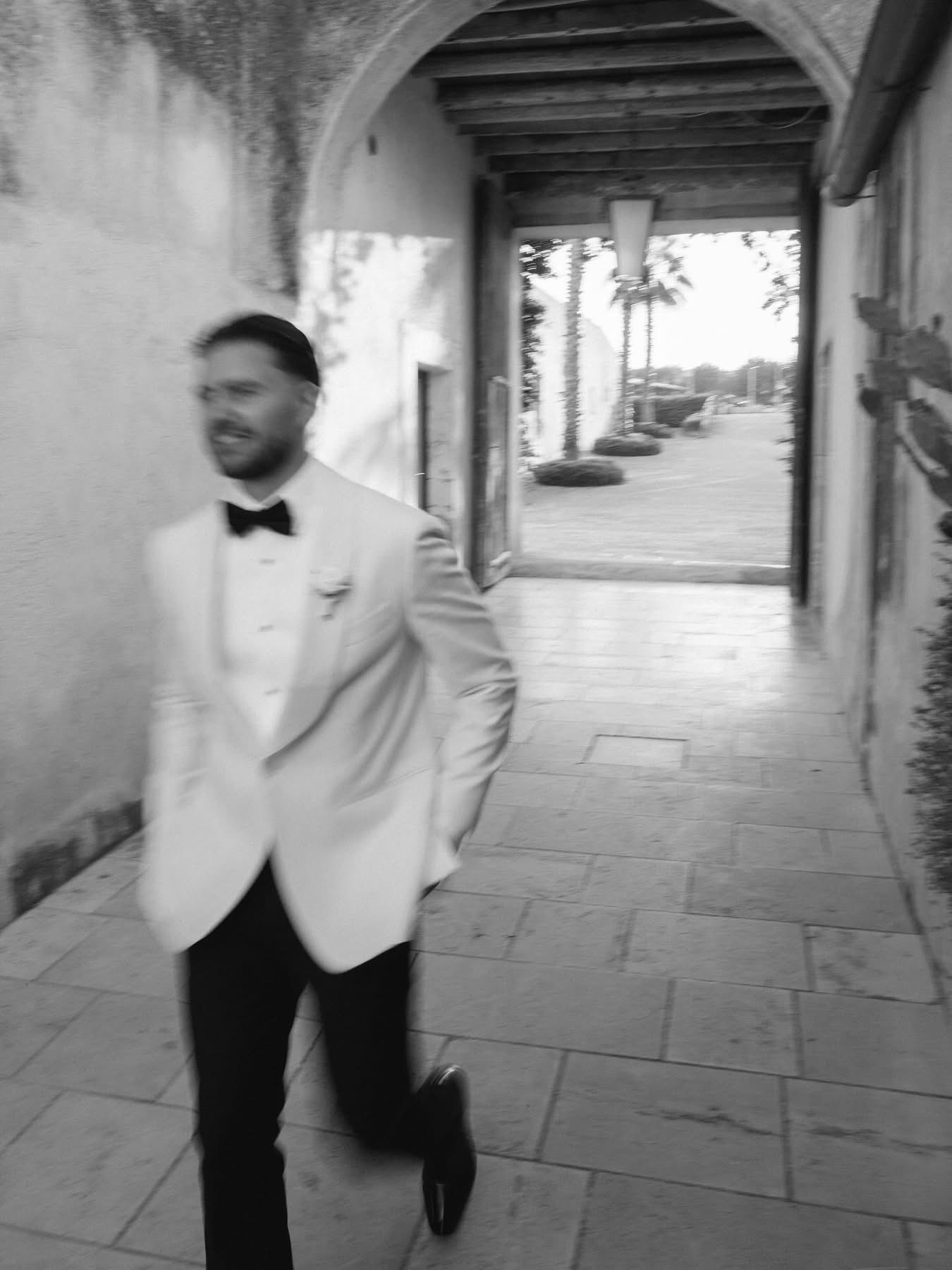 A black-and-white motion-blur photo of Rian in a stone corridor