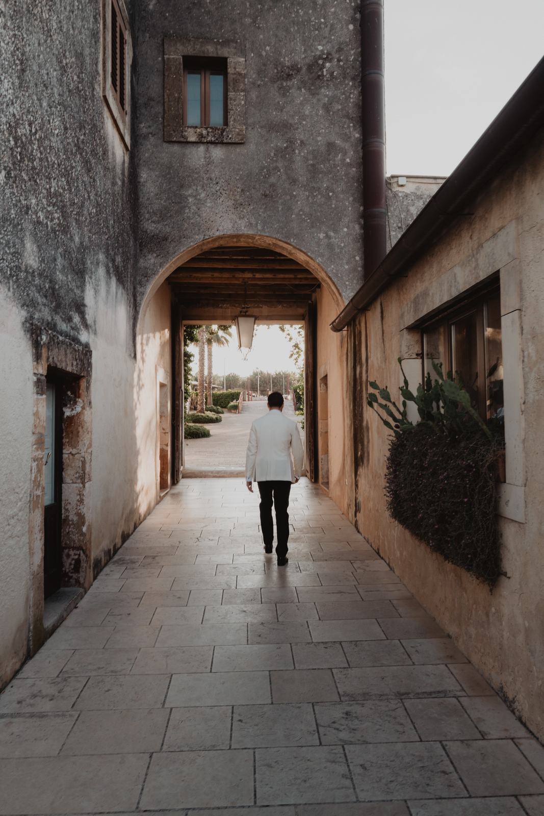 A stone archway and paved passage between the historic buildings of Borgo del Carato, Palazzolo Acreide
