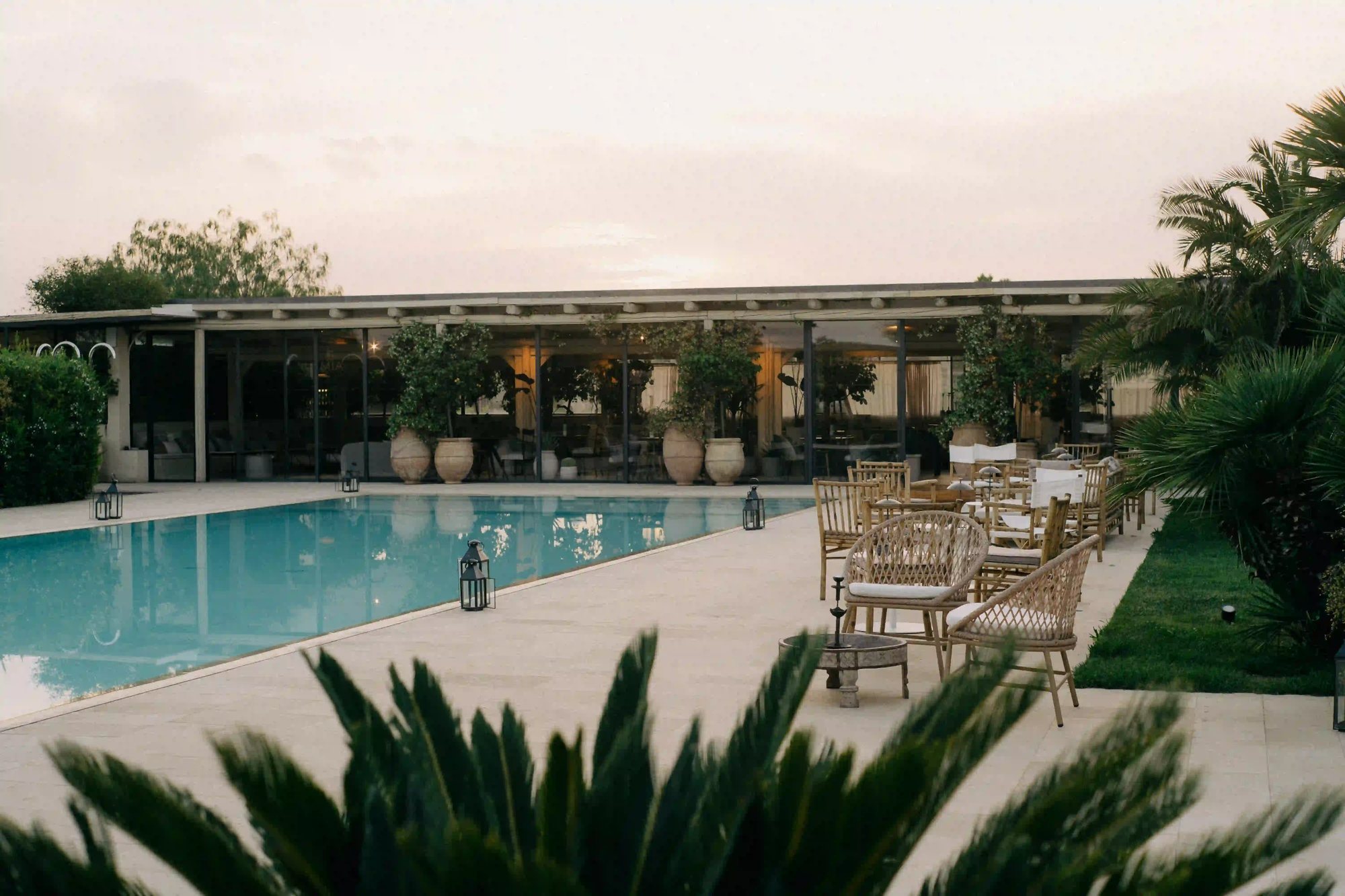 The saltwater pool and Lumìa Lounge at Dimora delle Balze, surrounded by palms and Mediterranean plants