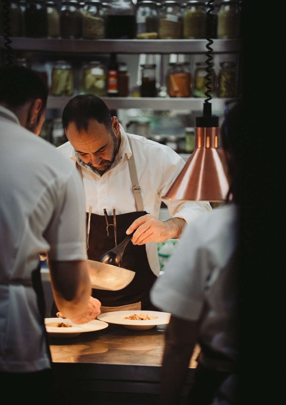 Chefs plating dishes in the kitchen of Lumìa Restaurant, the in-house restaurant at Dimora delle Balze