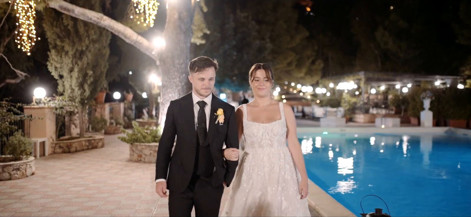 A bride and groom walking beside the pool at the Excelsior Palace in Taormina on their wedding night