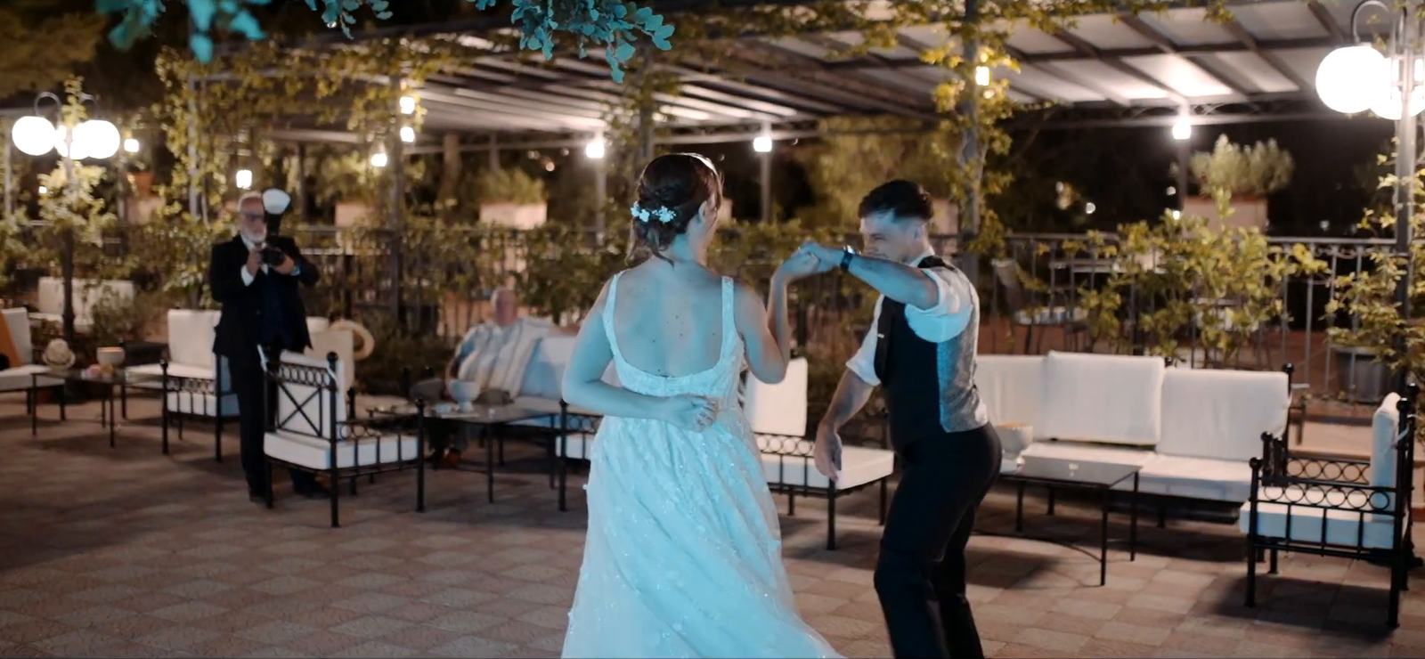 A first dance on the garden terrace of the Excelsior Palace in Taormina, beneath a pergola and string lights