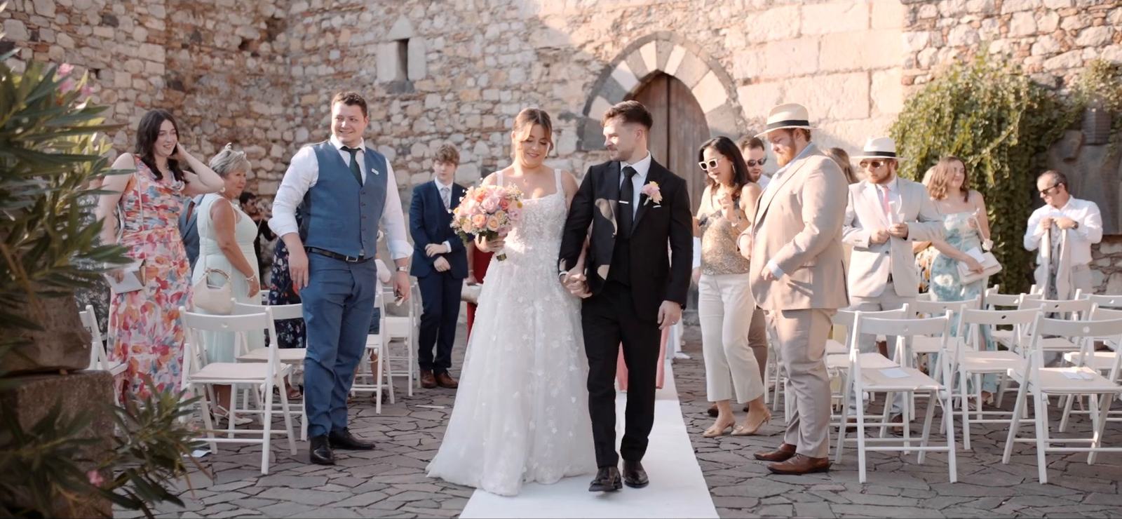 A bride and groom walking back down the aisle after their civil ceremony in the gardens of Palazzo Duchi di Santo Stefano, Taormina